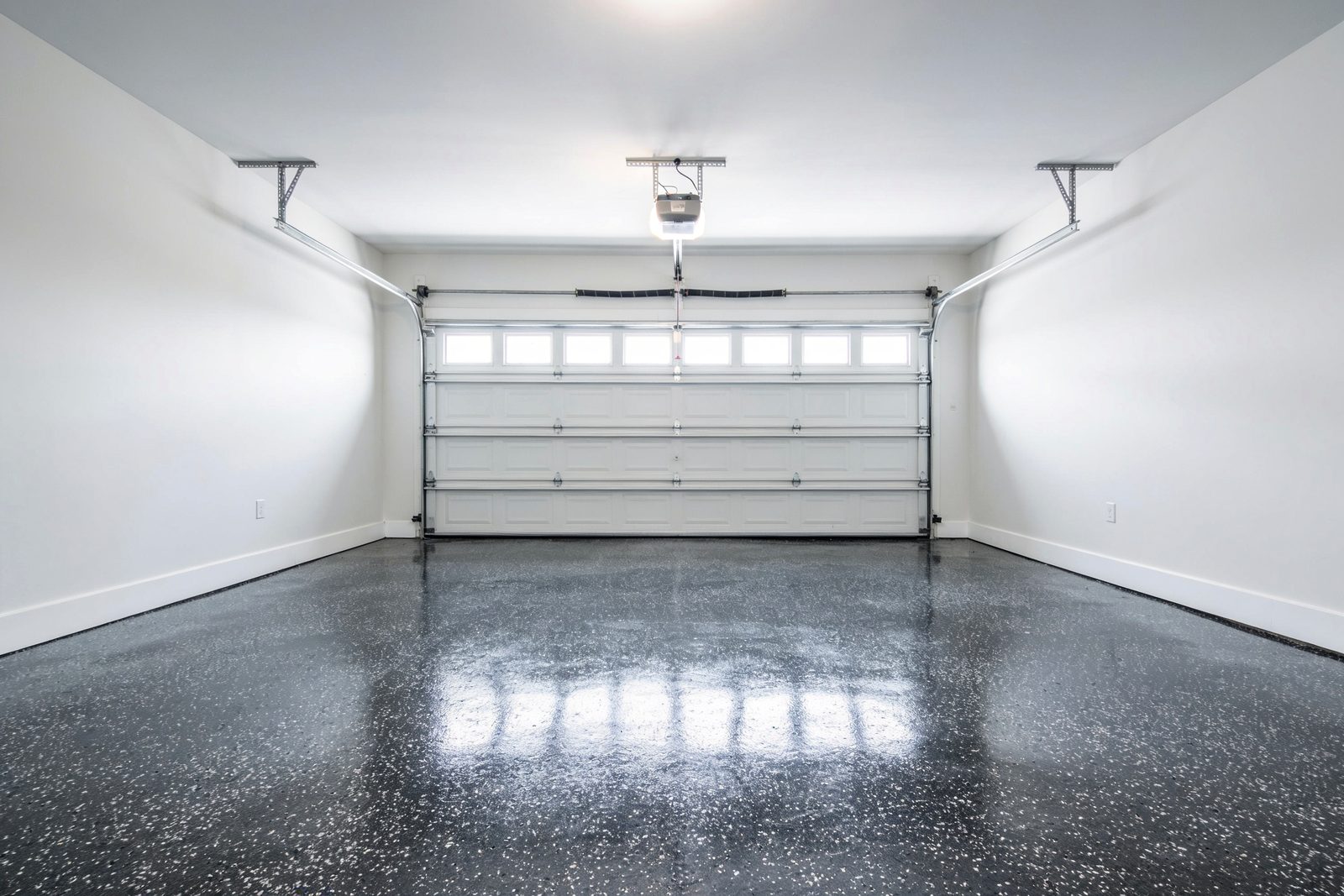 After: the same garage from the same position, finished with a charcoal and white flake coating and a high-gloss topcoat.